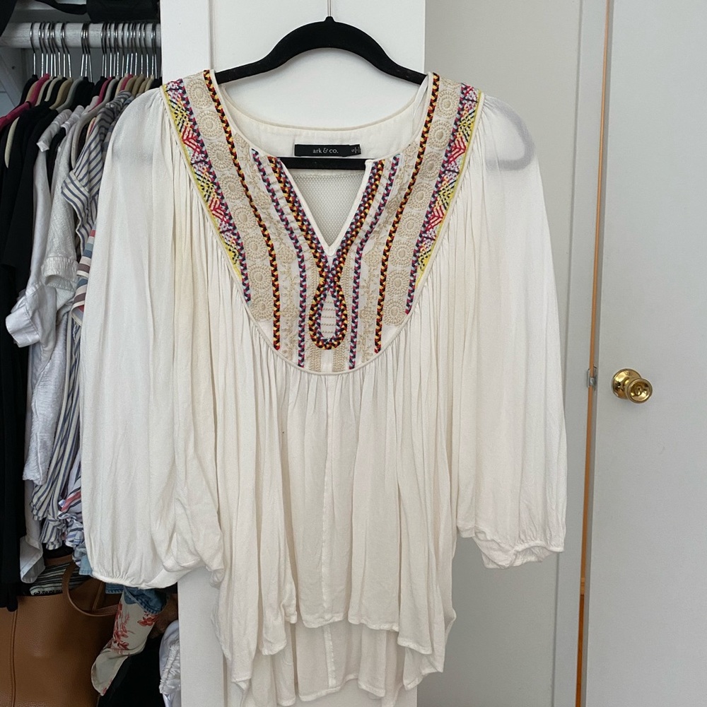 white billowy top with intricate woven collar